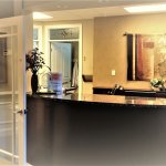 reception desk, with flowers and art on back wall